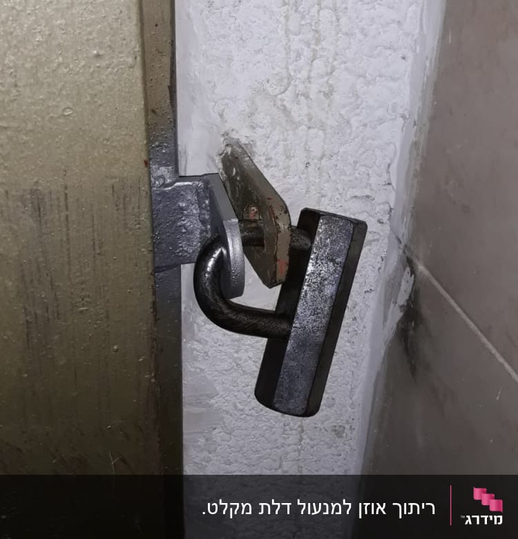מנעול מתכת על דלת מתכת במסגרת קיר בטון